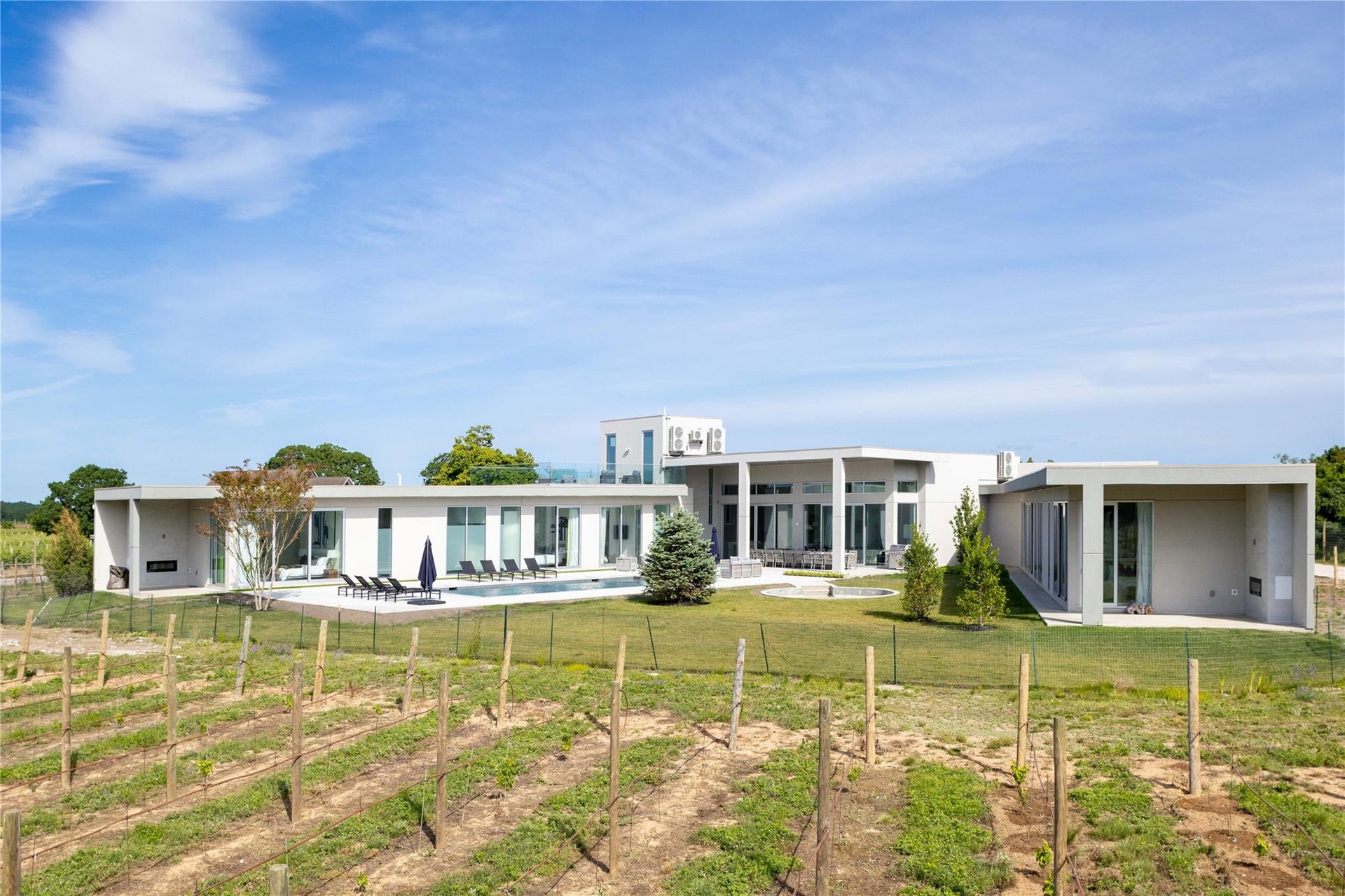 Back of property featuring a lawn, a rural view, and a patio