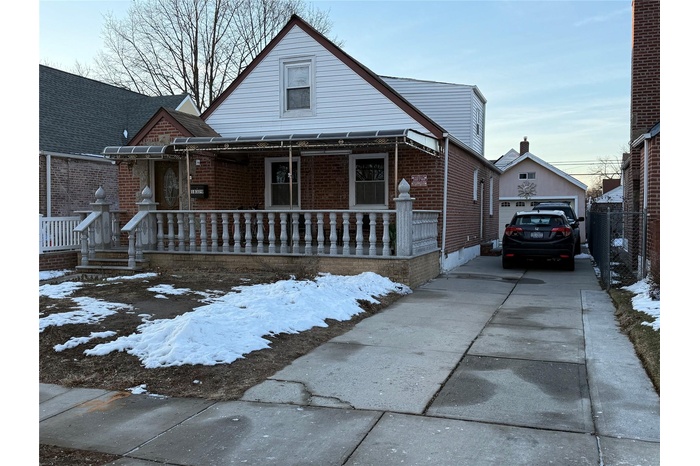 Bungalow-style house with a garage, an outdoor structure, and covered porch