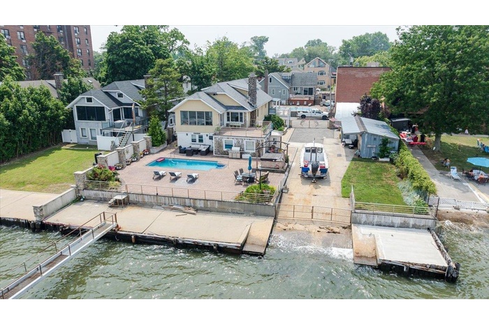 Rear view of house with a water view, a fenced backyard, a residential view, and a patio
