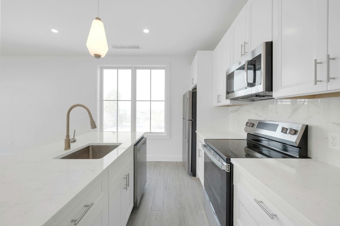 Kitchen Featuring, White Cabinetry, Quartz Countertops & Stainless Steel Appliances