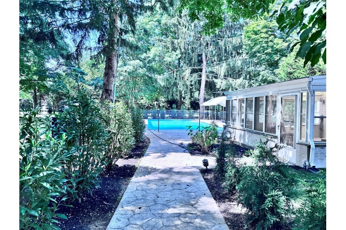 View of swimming pool with a sunroom