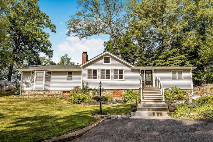 View of front of home featuring a chimney and a front yard
