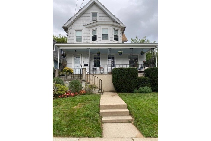 View of front facade with a porch and a front lawn