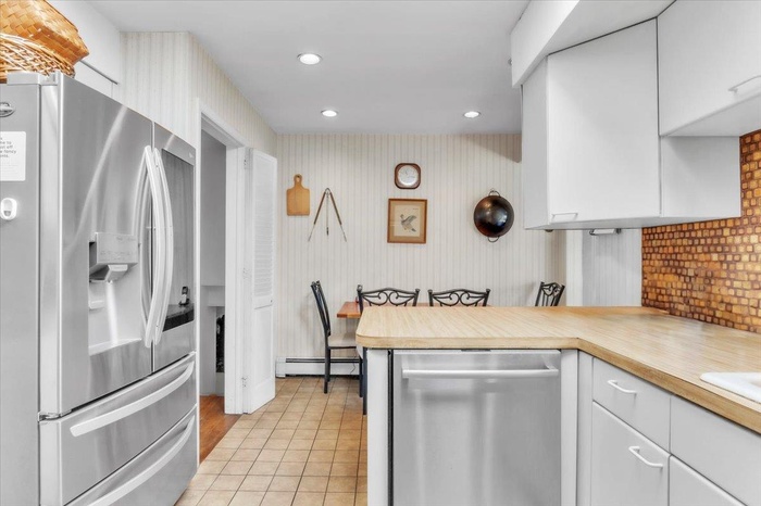 Kitchen featuring stainless steel appliances, light countertops, white cabinetry, recessed lighting, and light tile patterned floors