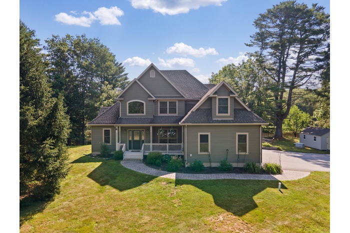 Craftsman-style home featuring a porch, a front lawn, and roof with shingles