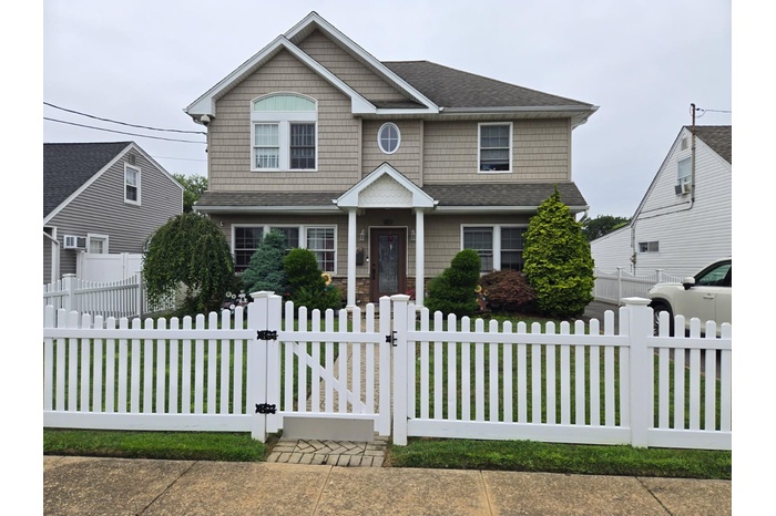 Craftsman inspired home featuring a gate, a fenced front yard, and roof with shingles