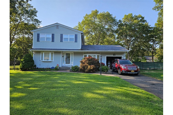 Traditional-style home with an attached garage and asphalt driveway