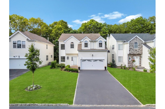 View of front of home featuring a garage, asphalt driveway, and a front lawn