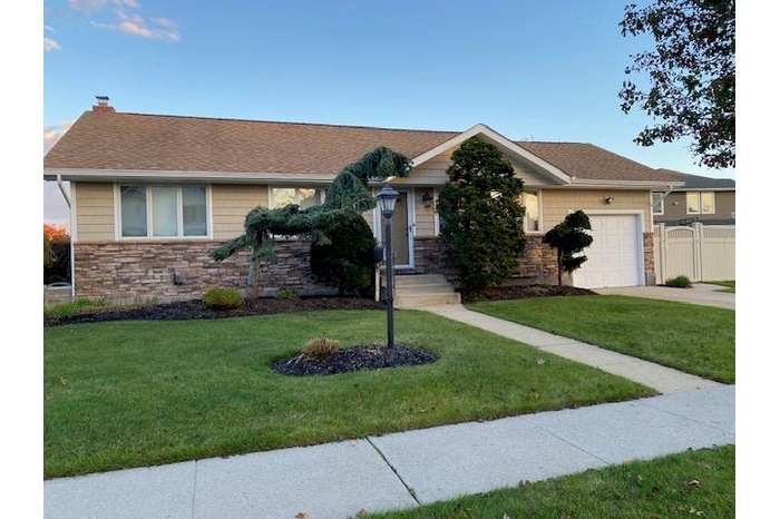 Ranch Style home with stone details and siding with 1 car attached garage and driveway