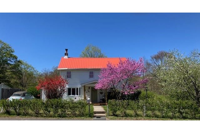 View of front of home with a chimney and a metal roof