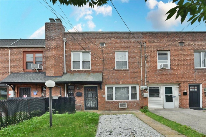 View of front of property with a chimney, brick siding, and cooling unit