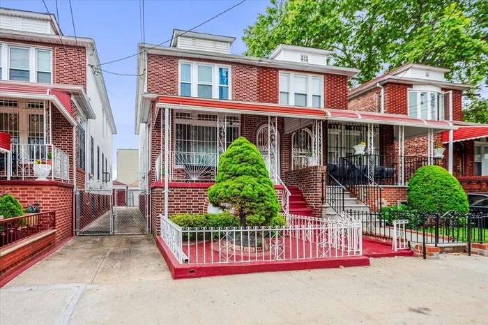 American foursquare style home with brick siding and a gate