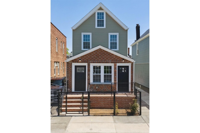 Traditional style home featuring a fenced front yard, brick siding, and a gate