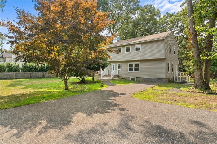 View of front of house with asphalt driveway and entry steps