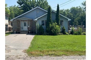 Bright Open Concept Three Bedroom Bungalow Featuring Large 100X220 Ft Lot, Wood Burning Stove, Propane Heating and AC, Large Eat In Kitchen with Walkout to Deck Overlooking Fenced Yard, Double ...