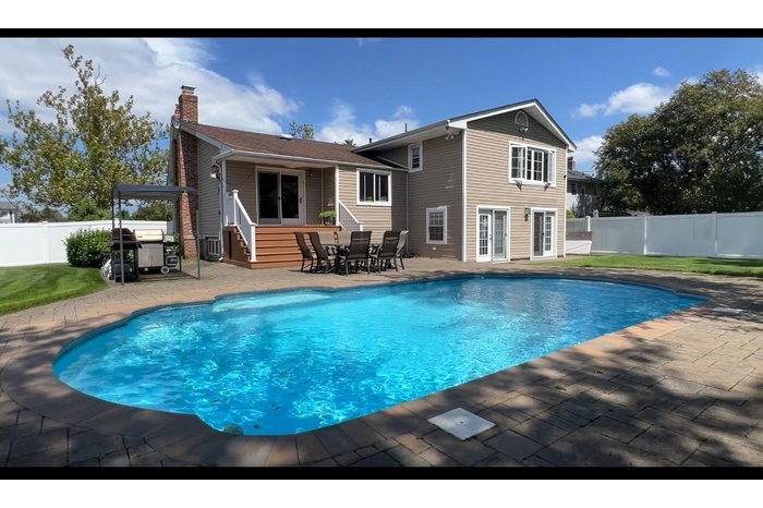 Back of house featuring a patio, a fenced backyard, and a chimney