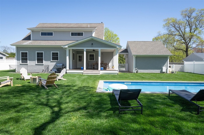 Rear view of property featuring ceiling fan, roof with shingles, a fenced backyard, and a patio