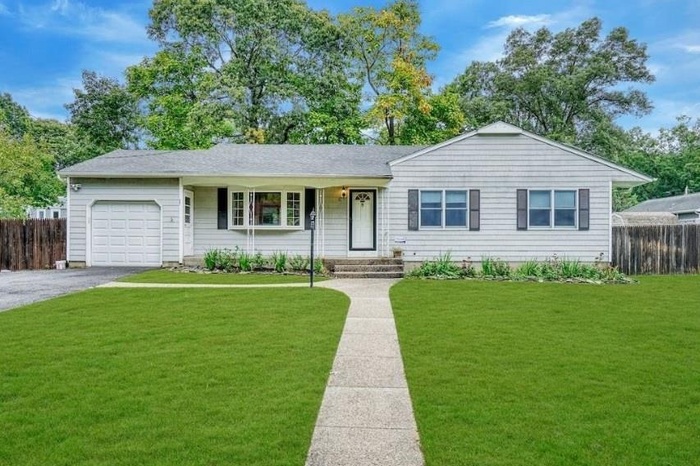 Ranch-style house with an attached garage and asphalt driveway