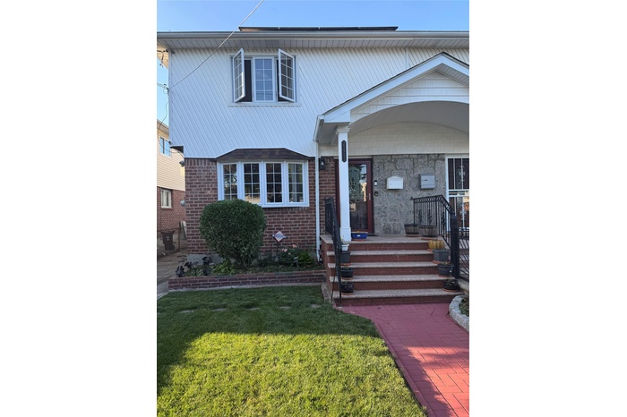 View of front of home featuring brick siding and a front yard