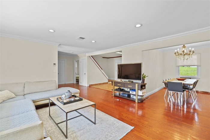 Living area complete with recessed lighting open to kitchen and dining area