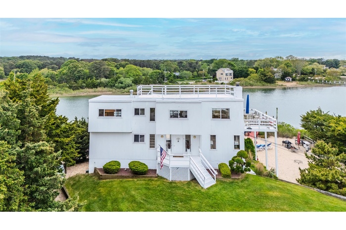 View of front facade with a water view and a front lawn