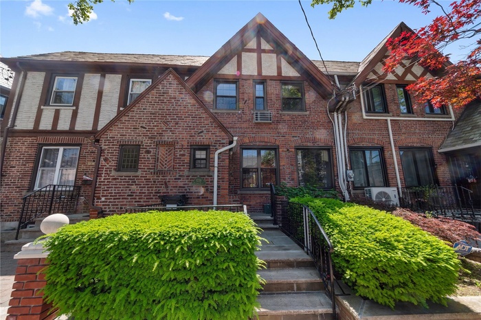 Tudor-style house featuring brick siding