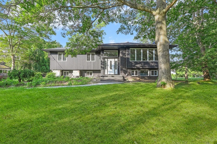 Bi-level home with a front yard and brick siding