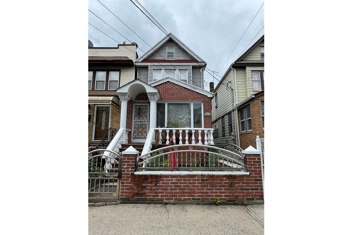 View of front of house with a fenced front yard, brick siding, and a gate