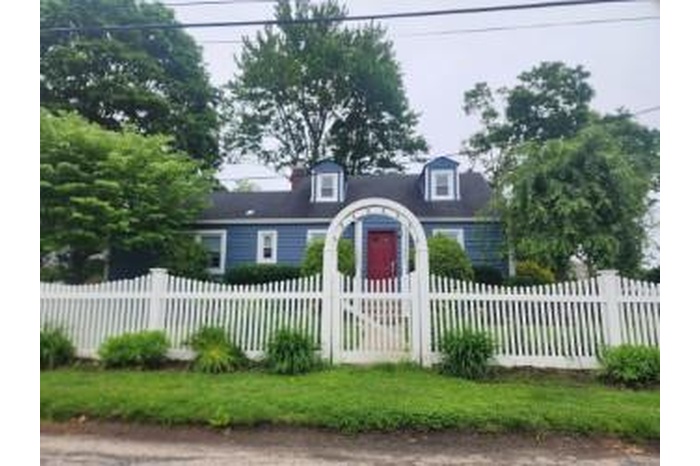 Cape cod-style house with a fenced front yard