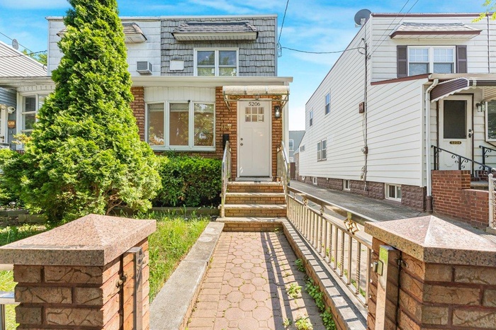 View of front of property featuring entry steps, mansard roof, and brick siding