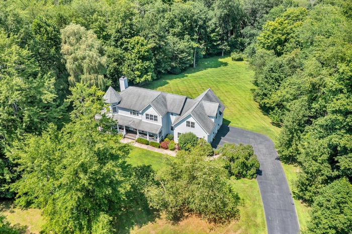 Aerial view of property and surrounding area featuring a heavily wooded area