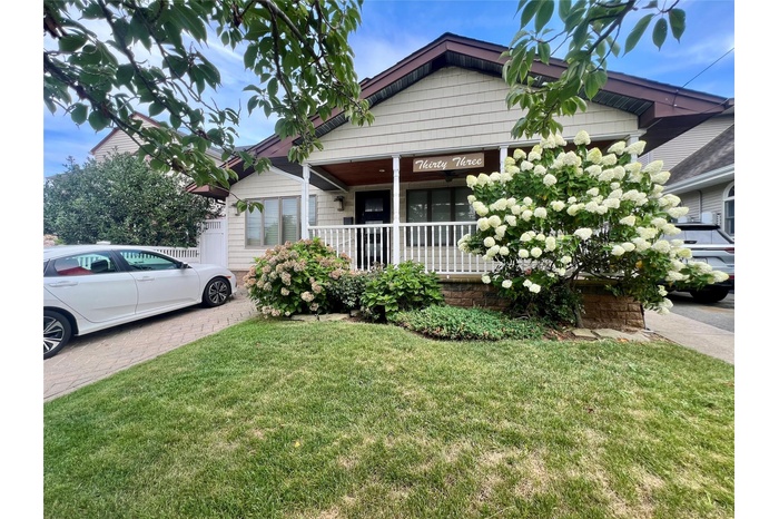 Bungalow-style home with a front yard and covered porch