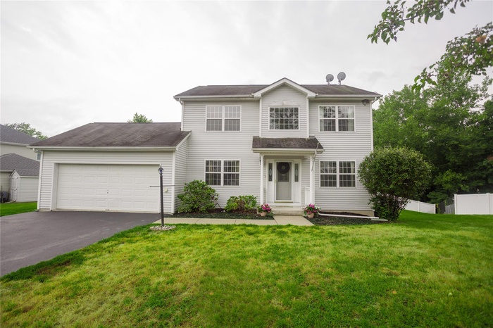 View of front of home featuring asphalt driveway and an attached garage