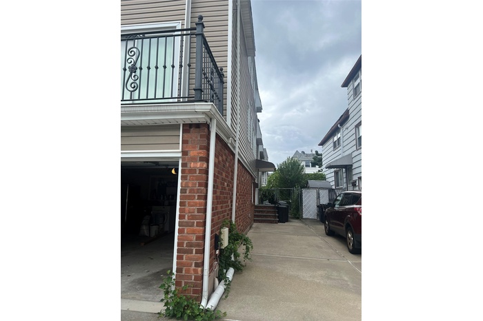 View of side of home featuring brick siding and a garage