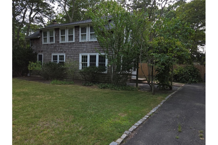 View of side of property featuring a lawn and a chimney