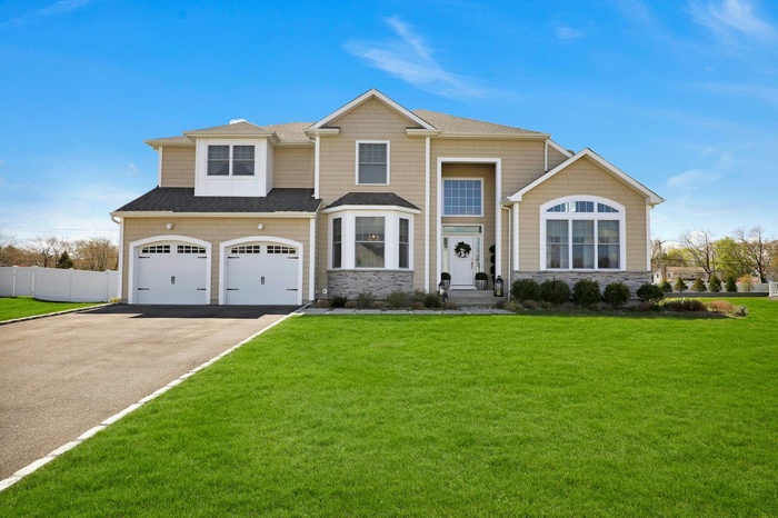 Craftsman-style home with asphalt driveway, an attached garage, roof with shingles, and stone siding