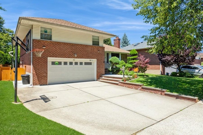 View of front of home with a garage, concrete driveway, and brick siding