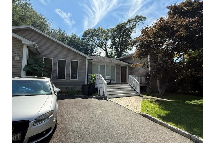 View of front of property with a front lawn and a shingled roof