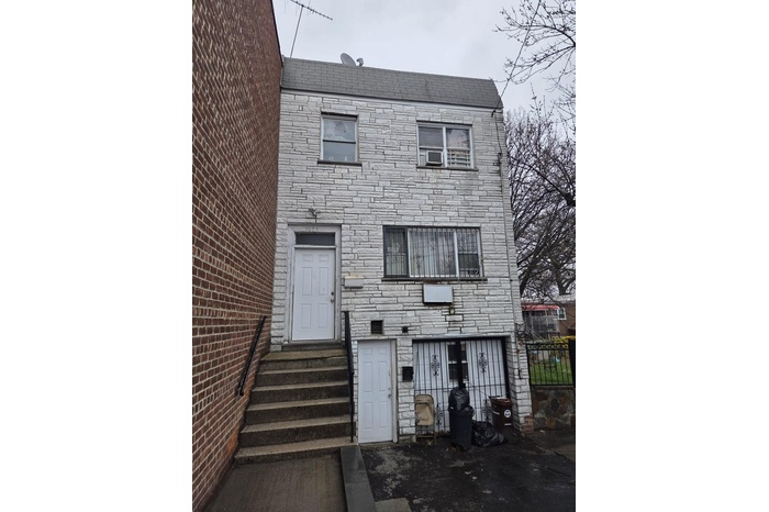 Townhome / multi-family property featuring entry steps and stone siding