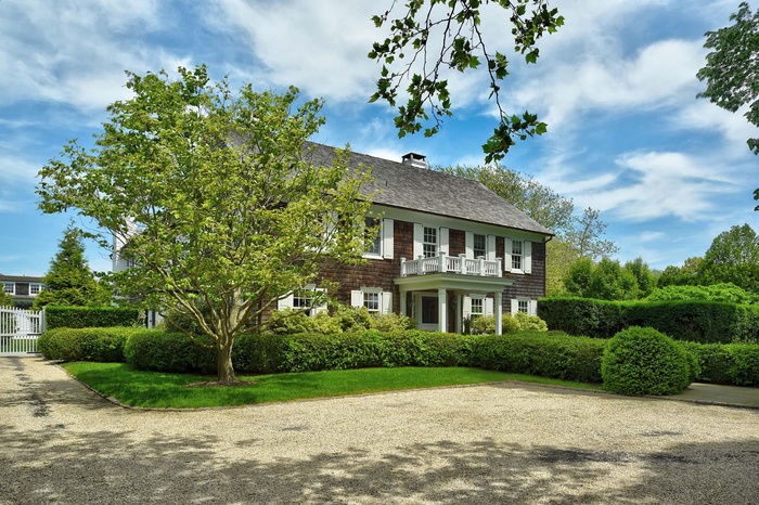 View of front of home with a balcony and a chimney