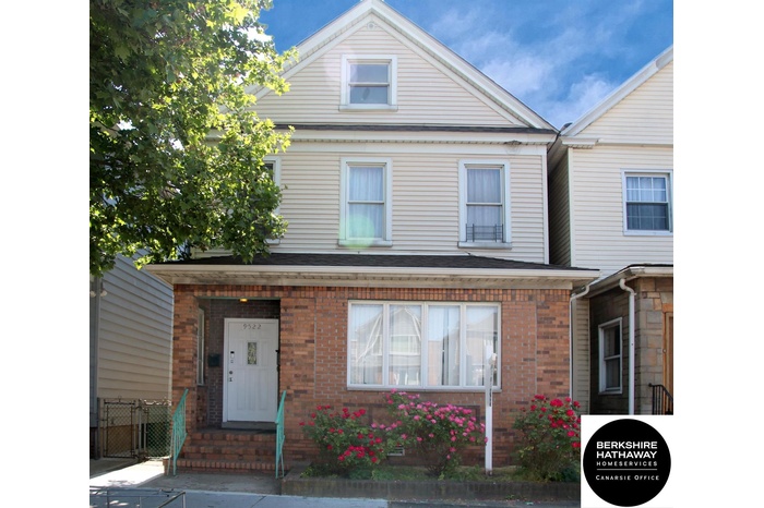 View of front of house featuring brick siding and fence