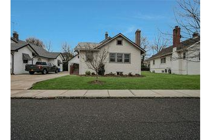 Front House lawn, concrete driveway, and an attached garage