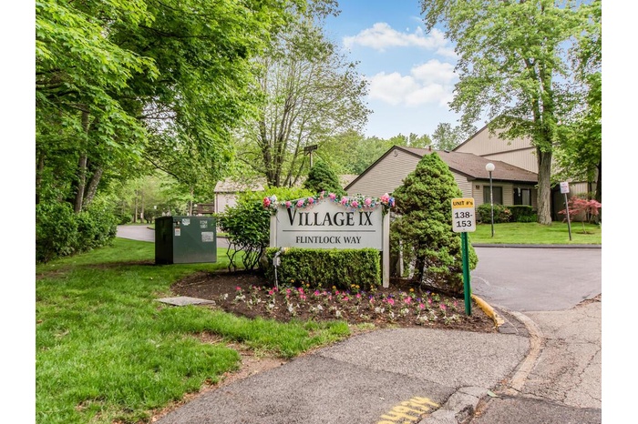 Community / neighborhood sign featuring a yard