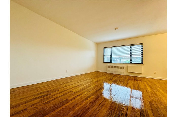 Empty room with hardwood / wood-style flooring and radiator