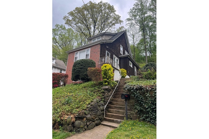 View of home's exterior featuring brick siding and stairway