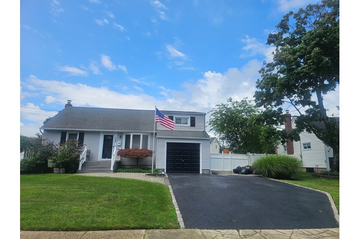 View of front facade featuring driveway and roof with shingles