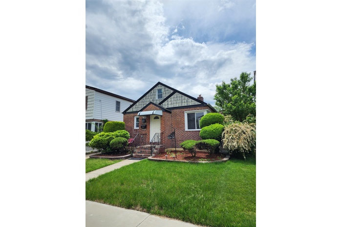 View of front facade with a front yard and brick siding
