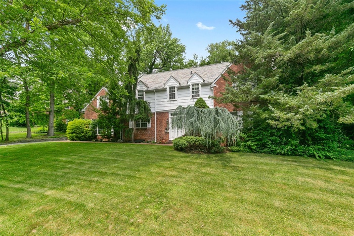 View of front of house with brick siding and a front lawn