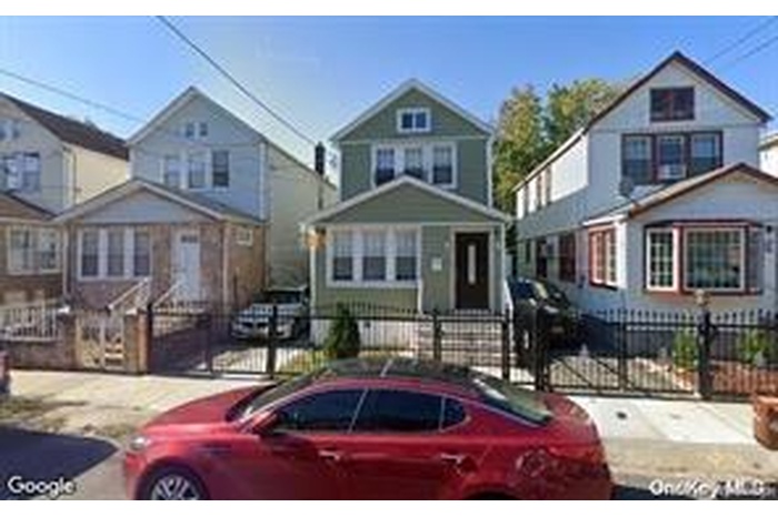 View of front of home with a residential view, a fenced front yard, and a gate