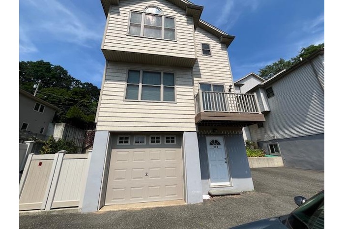 Traditional home featuring a balcony and a garage